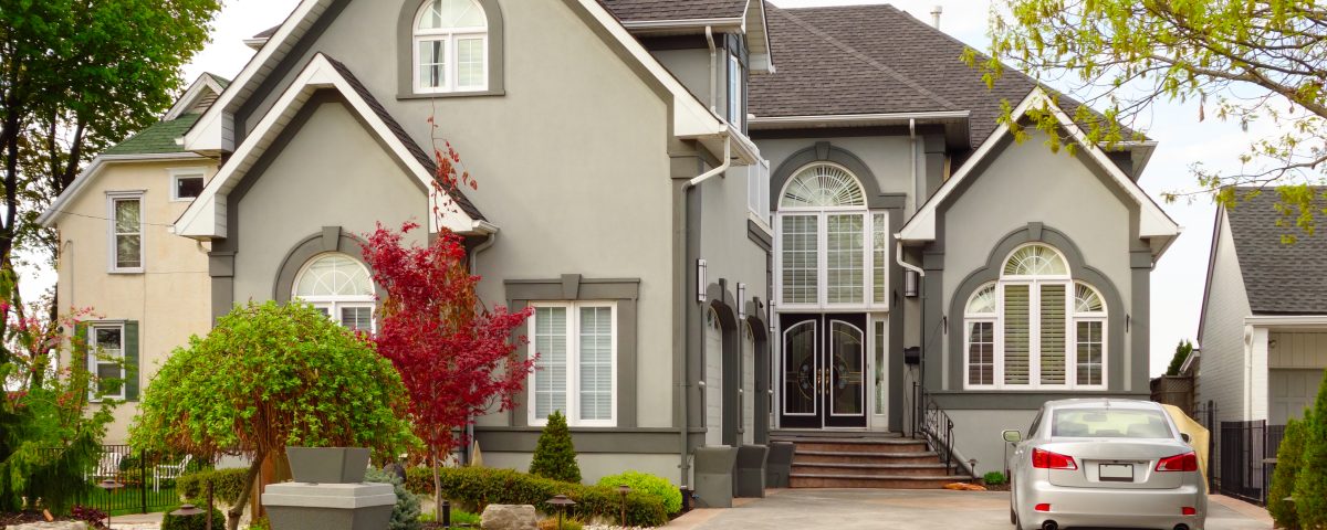 Large New House - Dow Brothers Painting LTD Front view of a large gray house with steep gables, arched windows, and a landscaped yard with a parked car in the driveway.
